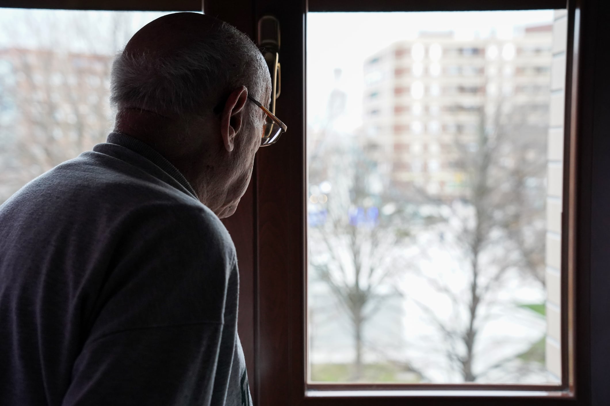 Un anciano mira por la ventana