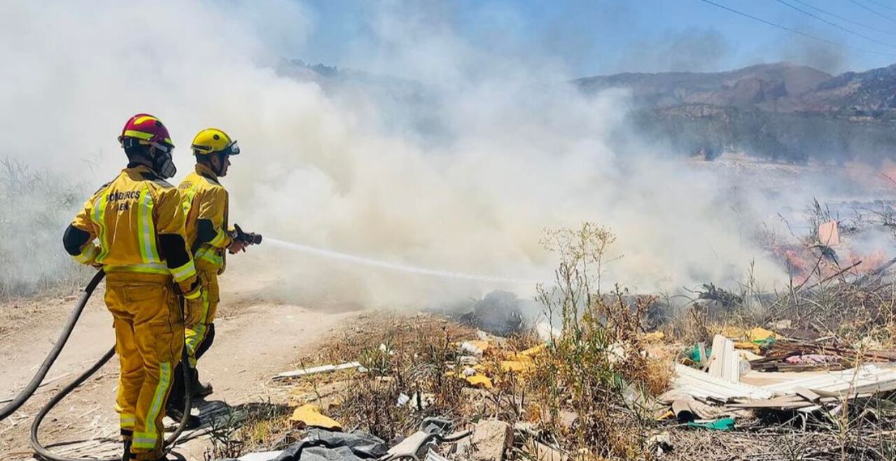 Bomberos intentando apagar un incendio en un solar cercano al centro comercial La Loma de Jaén.