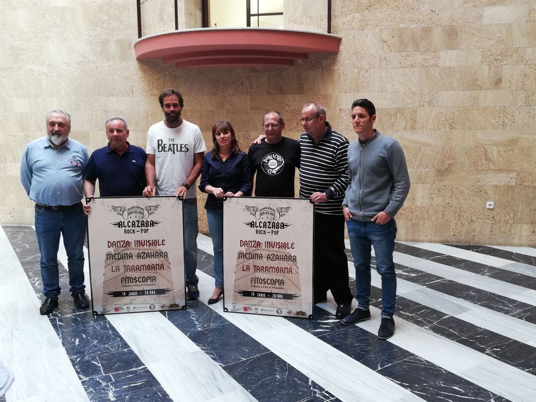 Laura Álvarez y los organizadores posan con el cartel del Alcazaba Rock-Pop.