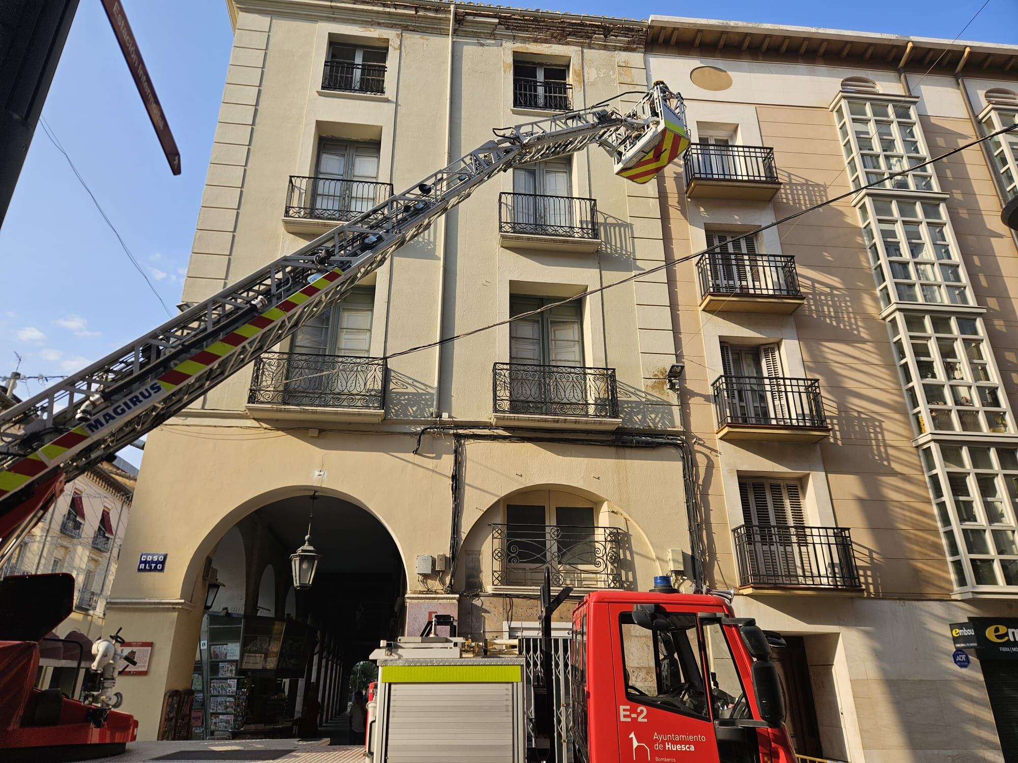 Los bomberos, actuando en el alero del edificio