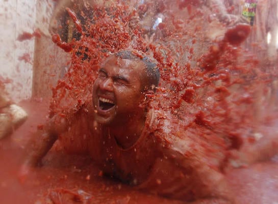 Un joven derrapa sobre el zumo de tomate durante la celebración de la &#039;Tomatina&#039;