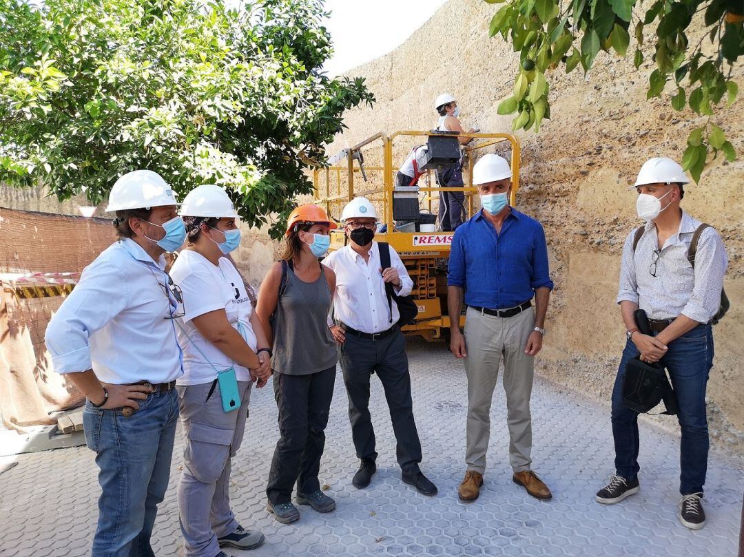 El delegado de Habita Urbano, Antonio Muñoz, segundo por la derecha, durante su visita este jueves a las obras de restauración de la Muralla de la Macarena