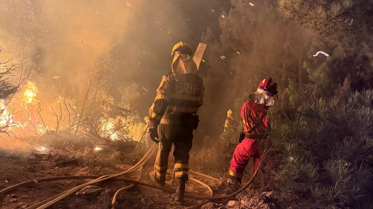 Dos personas trabajan en el control y extinción del incendio de Yeres (León).