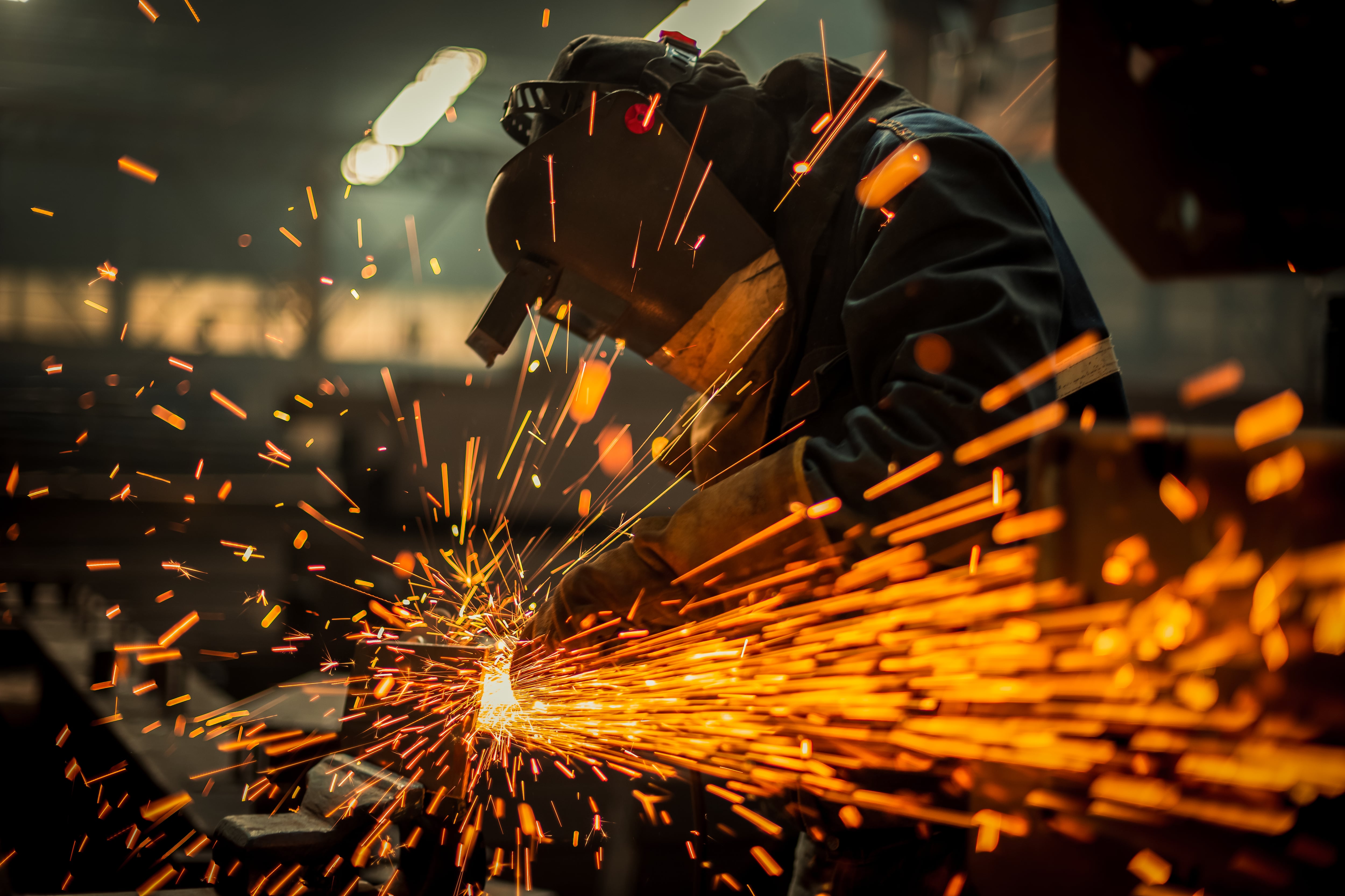 Trabajador del metal usando una radial en una imagen de archivo.