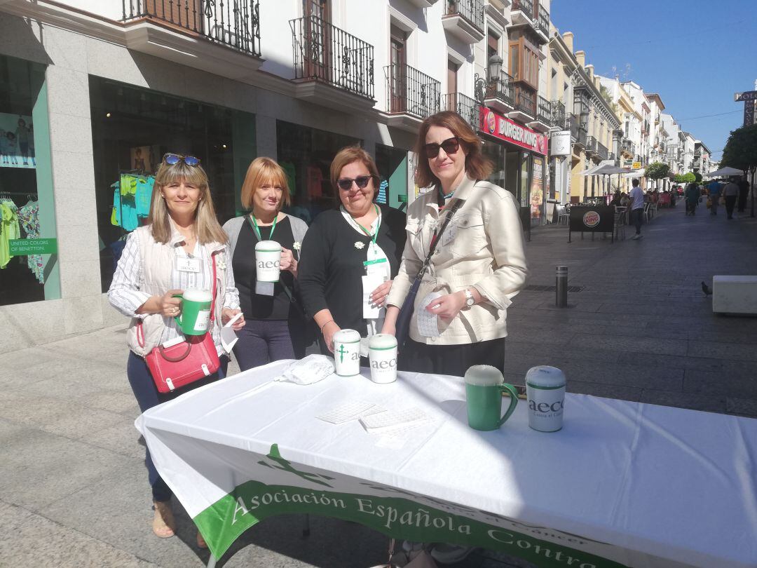 Miembros de la asociación en Ronda, entre ellas la presidenta de la AECC en la ciudad, junto a la mesa que han situado en Carrera Espinel