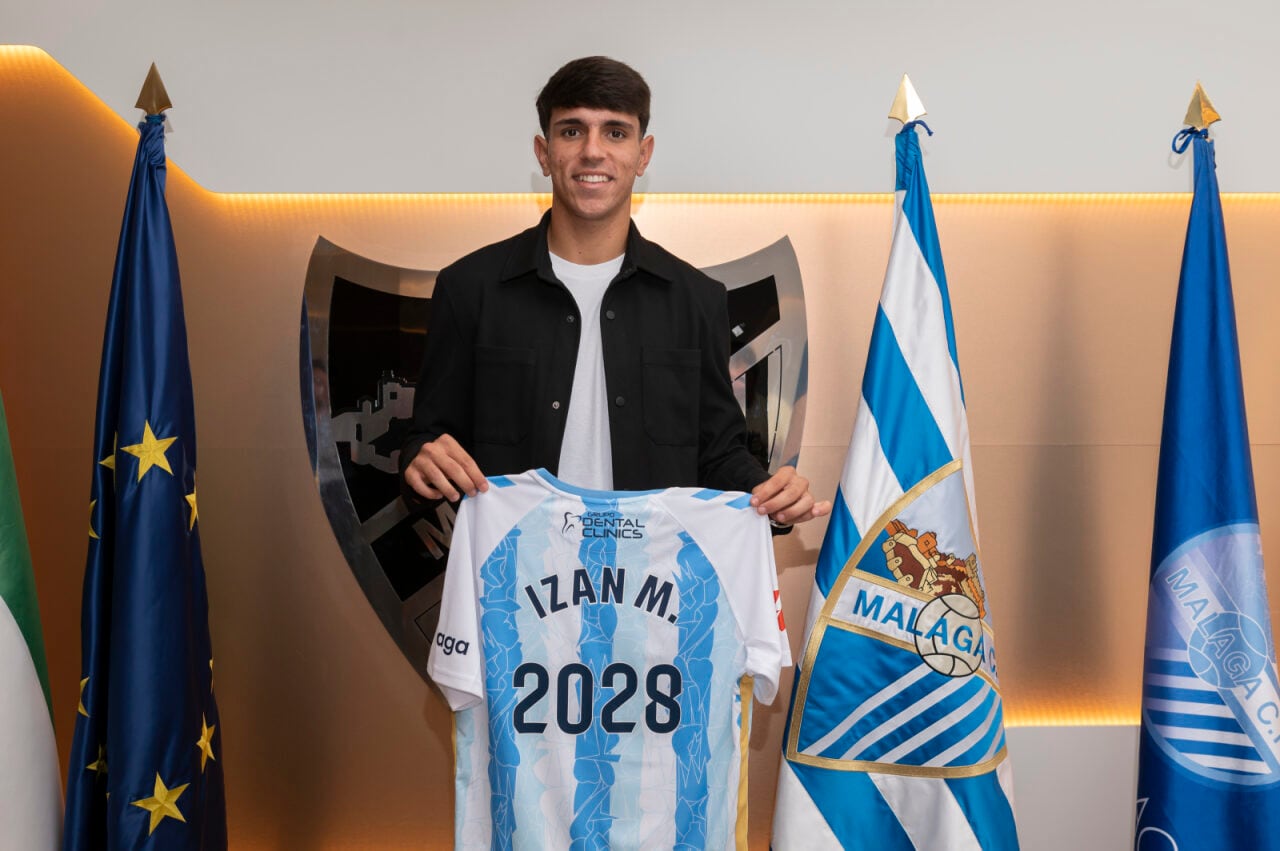 El centrocampista del Málaga Izan Merino posando con la camiseta blanquiazul, tras su renovación hasta 2028