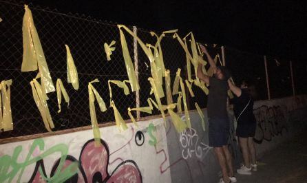 Retirada de lazos amarillos de una valla