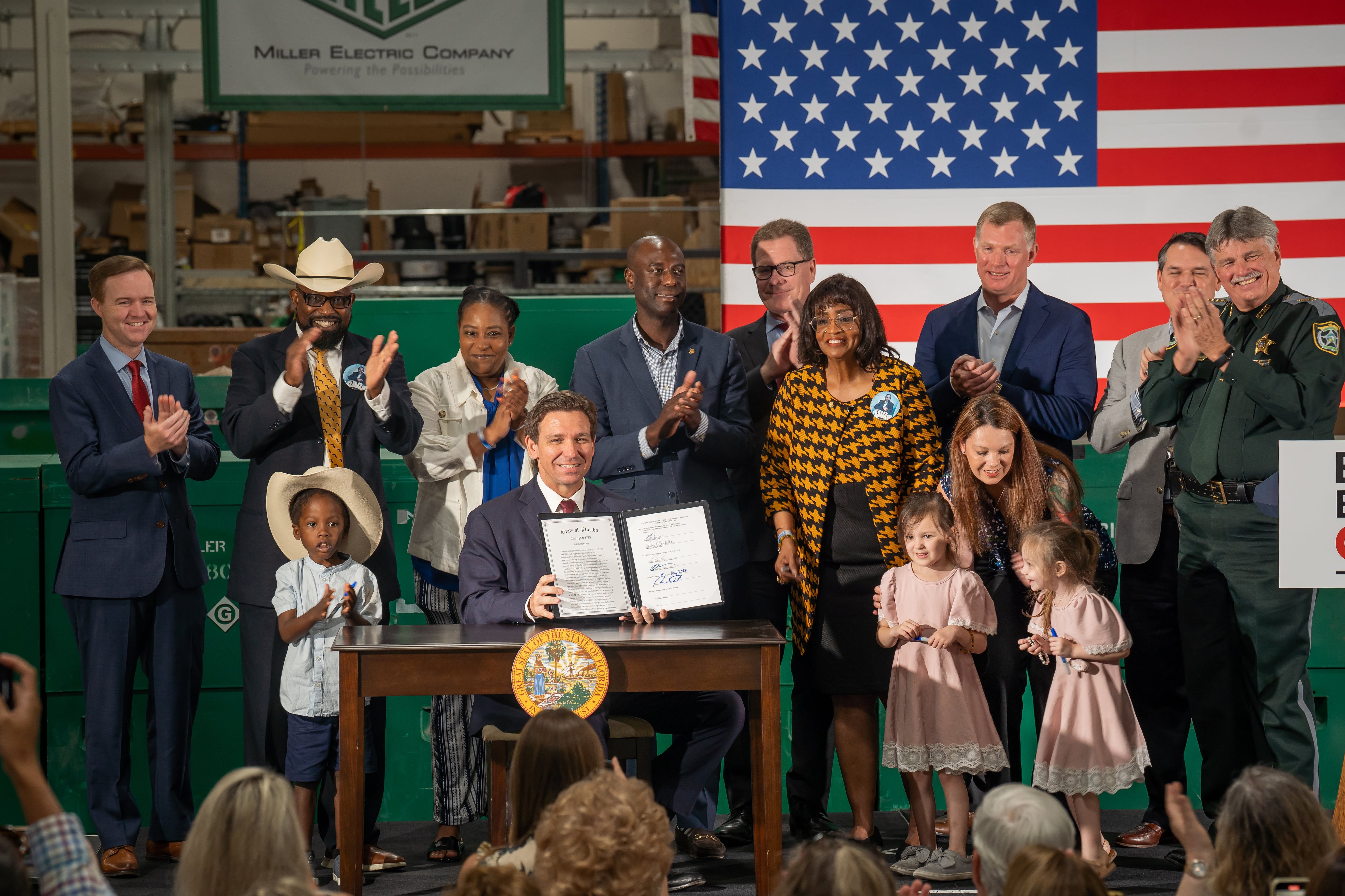 Fotografía cedida por la Gobernación de Florida donde aparece su gobernador Ron DeSantis mientras muestra la proclamación de la ley de inmigración tras su firma el 10 de mayo en Jacksonville, Florida.