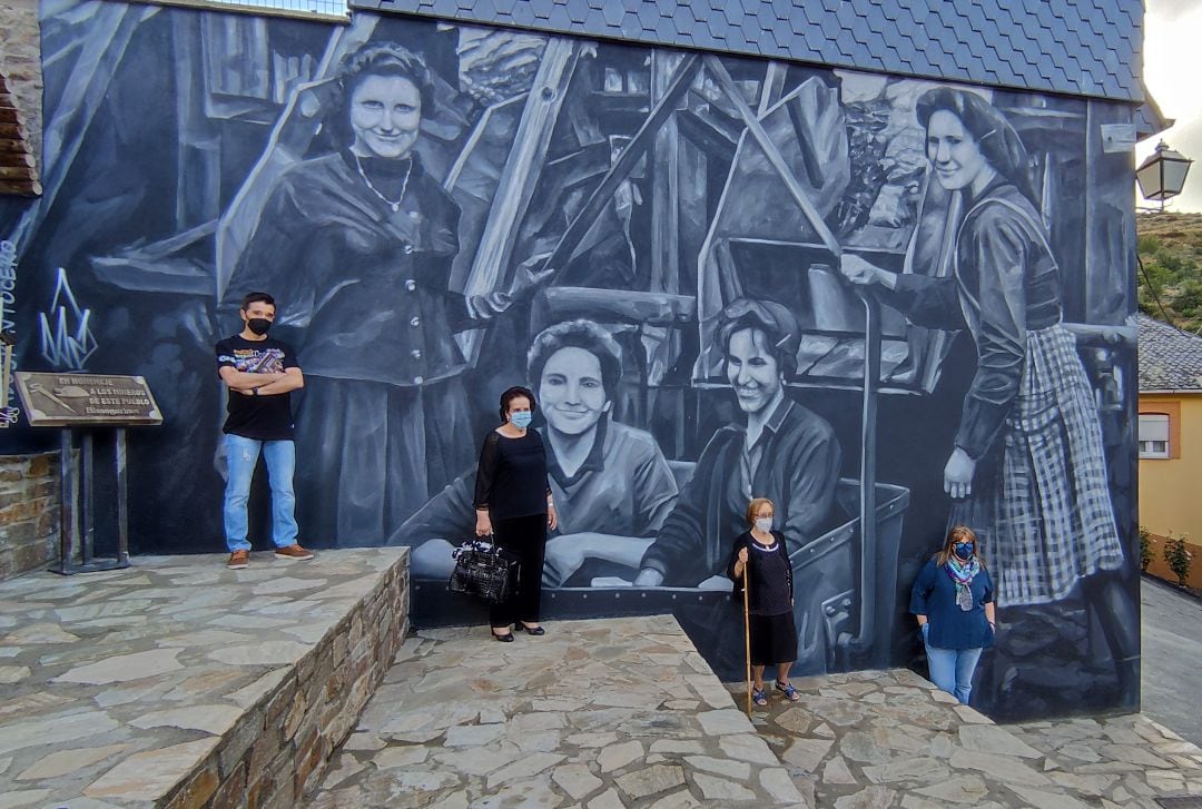 Dos de las homenajeadas, Begoña y Libertad Aurora posan delante de su retrato junto al ahijado de Hortensia y la hija de Irene