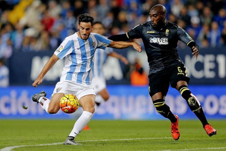 El defensa del Málaga Juan Carlos Pérez (i), se dispone a chutar ante el defensa francés del Granada Jean-Sylvain Babin durante el partido Málaga - Granada