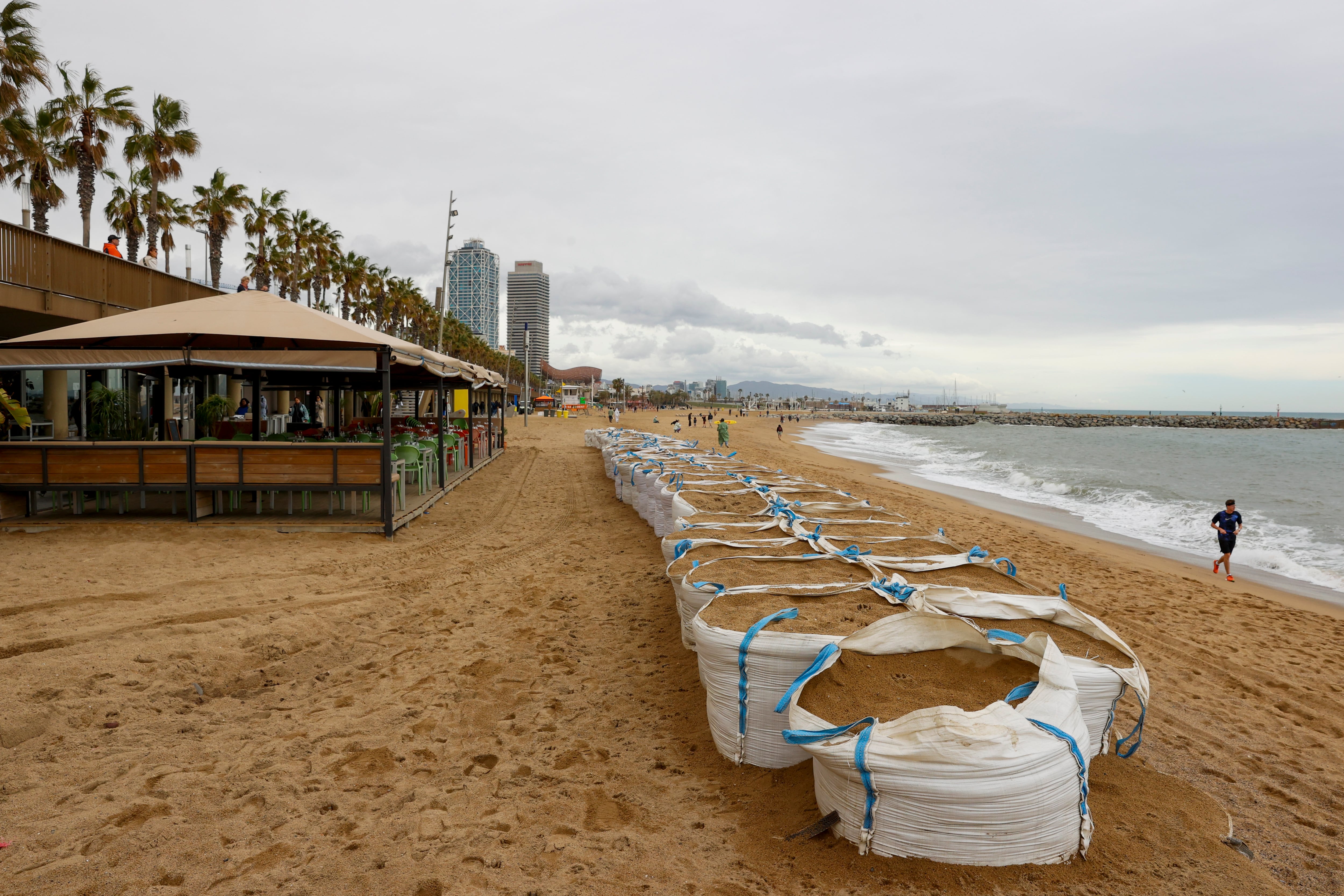 Unas bolsas llenas de arena para proteger la playa de la Barceloneta este domingo en que Protección Civil de la Generalitat ha levantado la alerta del plan Procicat por fuerte oleaje en las playas catalanas, que esta semana ha ocasionado, en varios episodios de mala mar, daños en paseos y arenales de diversos municipios catalanes. EFE/ Toni Albir