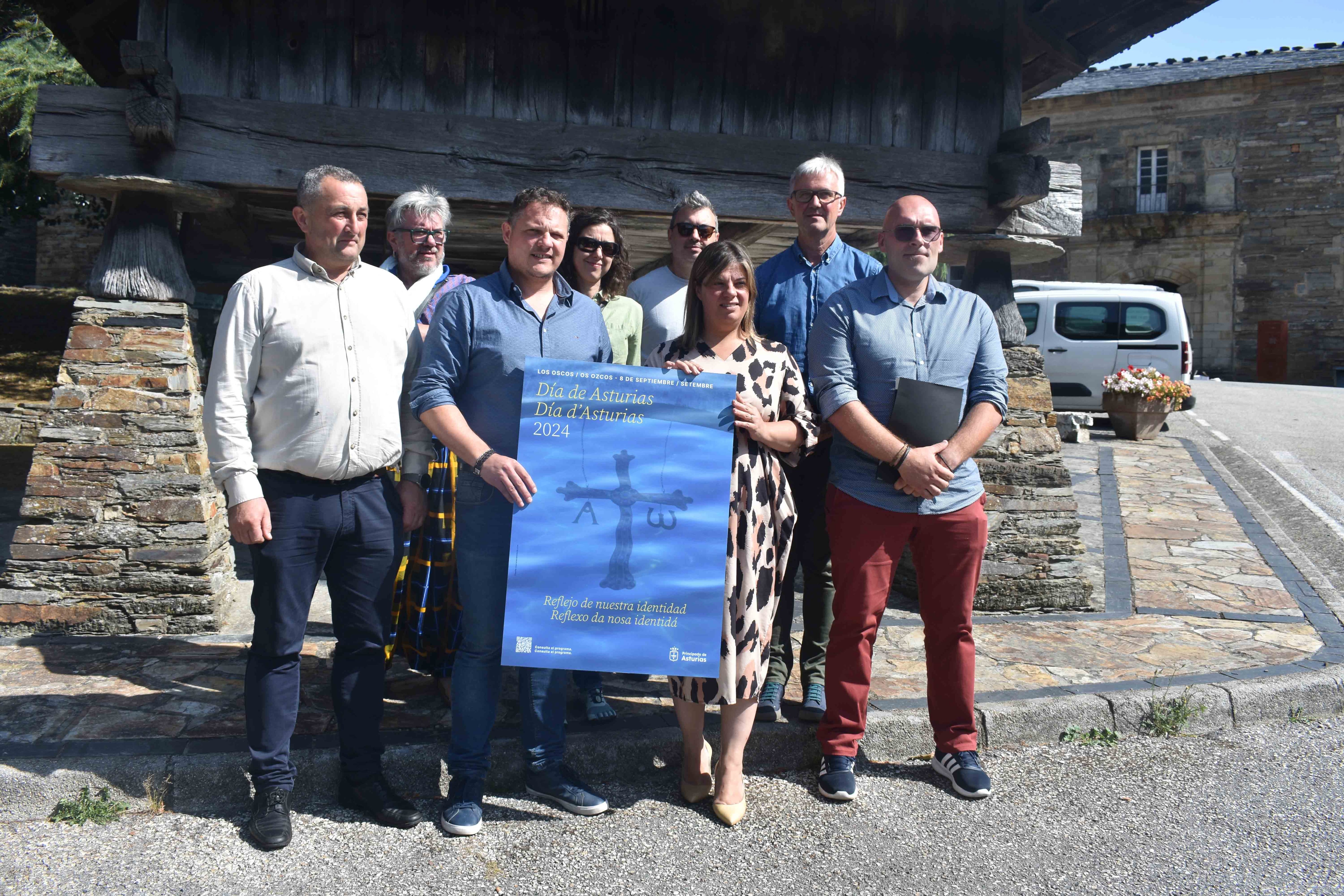 LLamedo (en el centro, sosteniendo el cartel) ha acudido a Los Oscos para presentar el programa de actos del Día de Asturias.