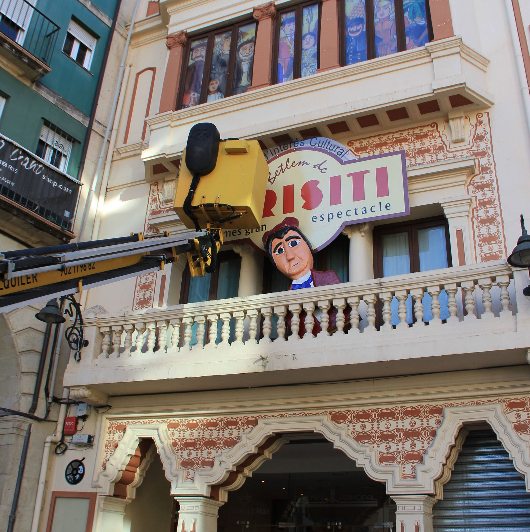 Imagen de la grúa colocando el cartel del Betlem de Tirisiti en la fachada del Teatre Principal