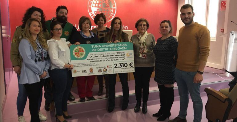 Resoionsables de la Tuna Unviersitaria del Distrito de Jaén entregan el cheque a la asociación &#039;Pídeme la Luna&#039;.