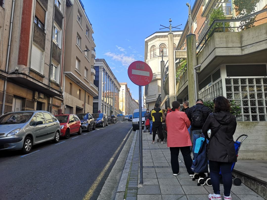 Beneficiarios del Economato hacen cola en la puerta de la Cocina Económica en Santander.