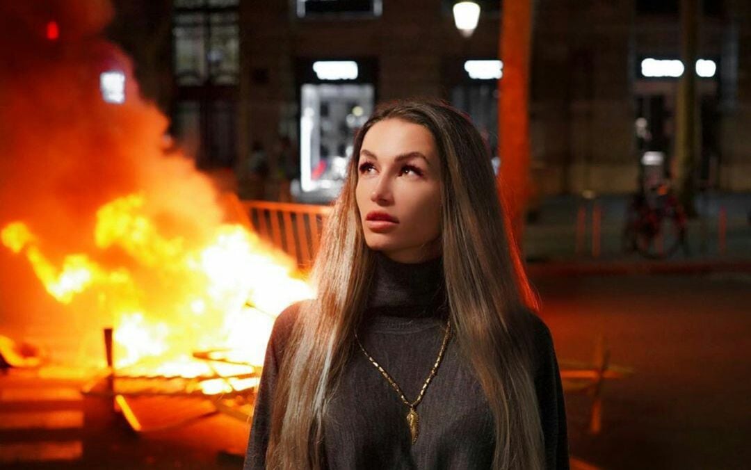 Una joven se fotografía frente al fuego.