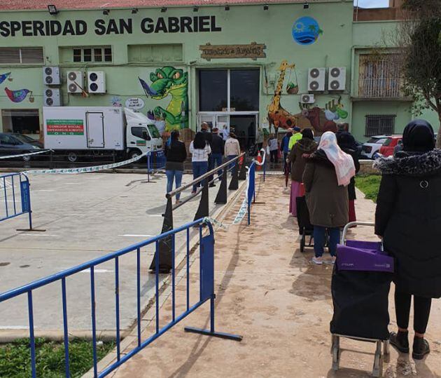 Grupos de personas que hacen cola para pedir alimentos