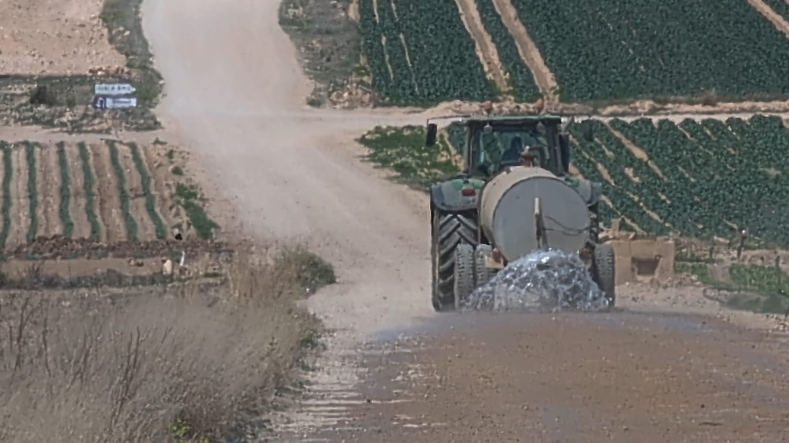 Cuba regando uno de los caminos públicos al lado de una explotación agrícola