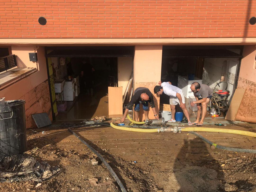 Els veïns traient aigua i fang dels soterranis