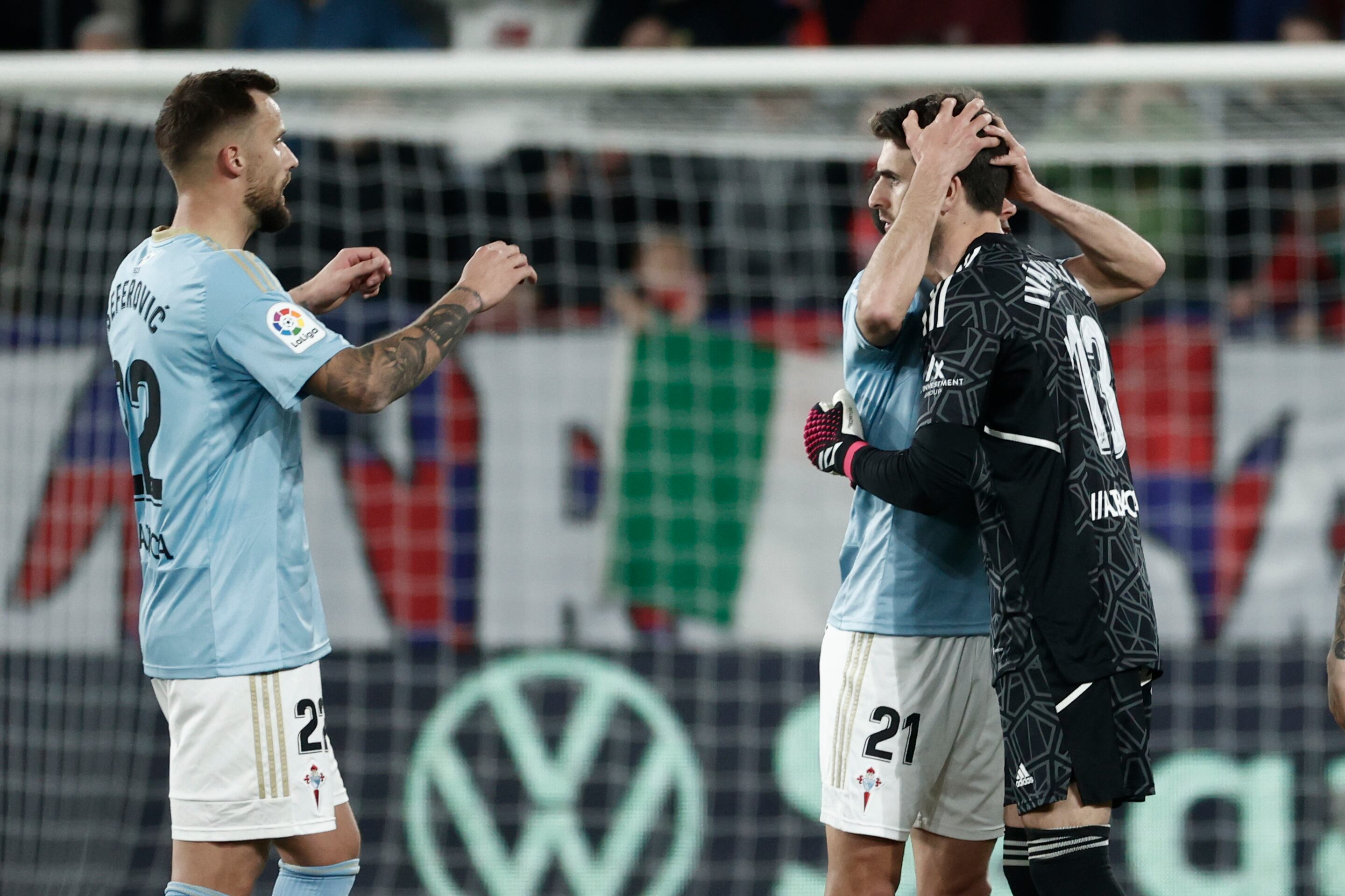 PAMPLONA, 06/03/2023.- Los jugadores del Celta, el suizo Haris Seferovic (i) y el argentino Augusto Solari, felicitan a su guardameta Iván Villar, a la finalización del encuentro correspondiente a la jornada 24 de primera división que han disputado hoy lunes frente a Osasuna en el estadio El Sadar de Pamplona. EFE / Jesús Diges.
