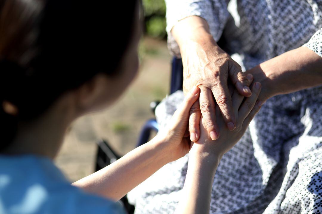 Una residente recibe los cuidados de una trabajadora. 