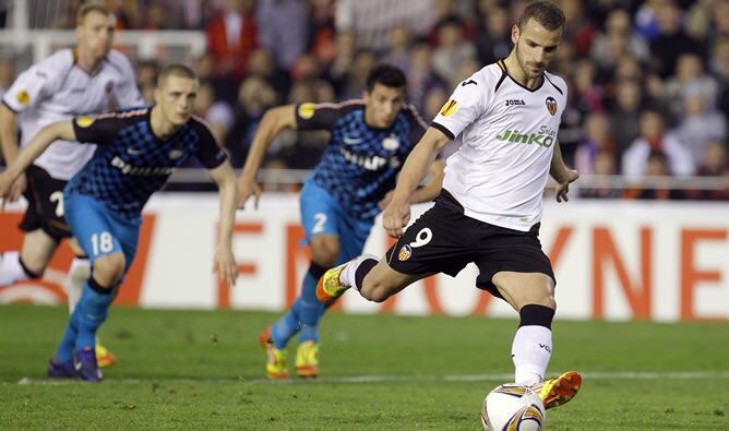 El delantero del Valencia, Roberto Soldado, en el momento de lanzar el penalti que ha supuesto el tercer gol del equipo valencianista