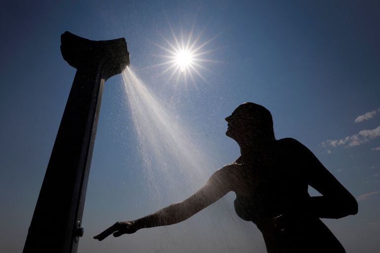 Una mujer toma una ducha para refrescarse del calor.