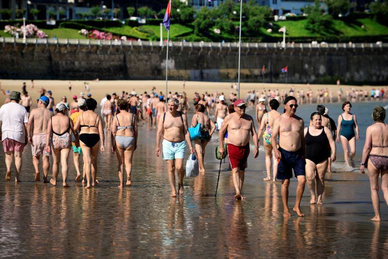 Donostiarras y turistas pasean por la playa de La Concha.