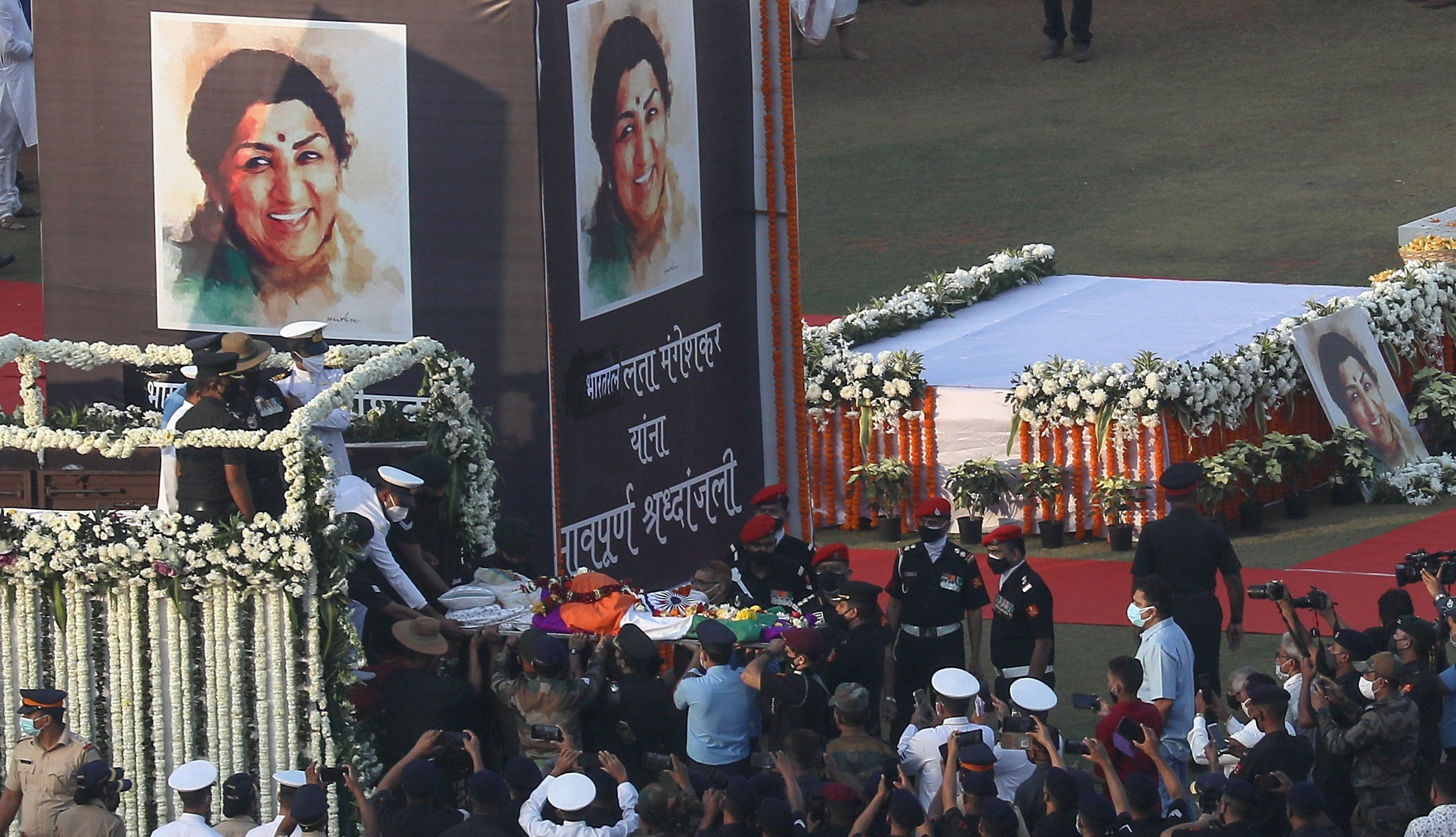 Mumbai (India), 06/02/2022.- People gather near the vehicle carrying the mortal remains of legendary singer Lata Mangeshkar during the funeral procession at Shivaji Park in Mumbai, India, 06 February 2022. Lata Mangeshkar passed away at 92 in Mumbai after she was treated for COVID-19 and pneumonia symptoms nearly for a month. EFE/EPA/DIVYAKANT SOLANKI
