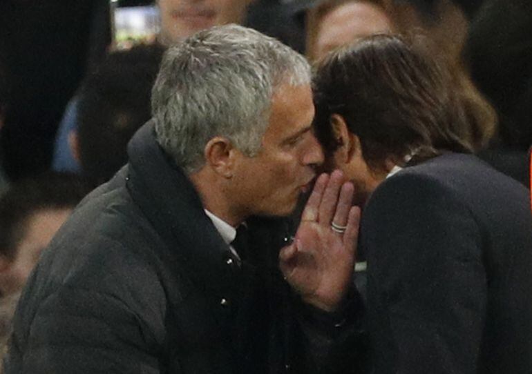 El técnico del Chelsea, Antonio Conte, escucha lo que le dice Moruinho al oído.