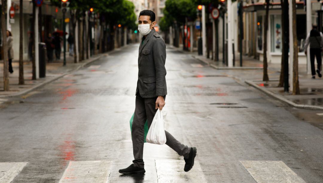 Una persona con mascarilla recorre las calles de Murcia.