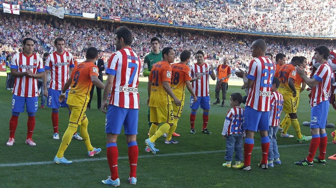 Los jugadores del Atlético de Madrid hacen pasillo a los del Barcelona por su reciente proclamación como campeones de Liga antes del partido correspondiente a la trigésimo quinta jornada en Primera.