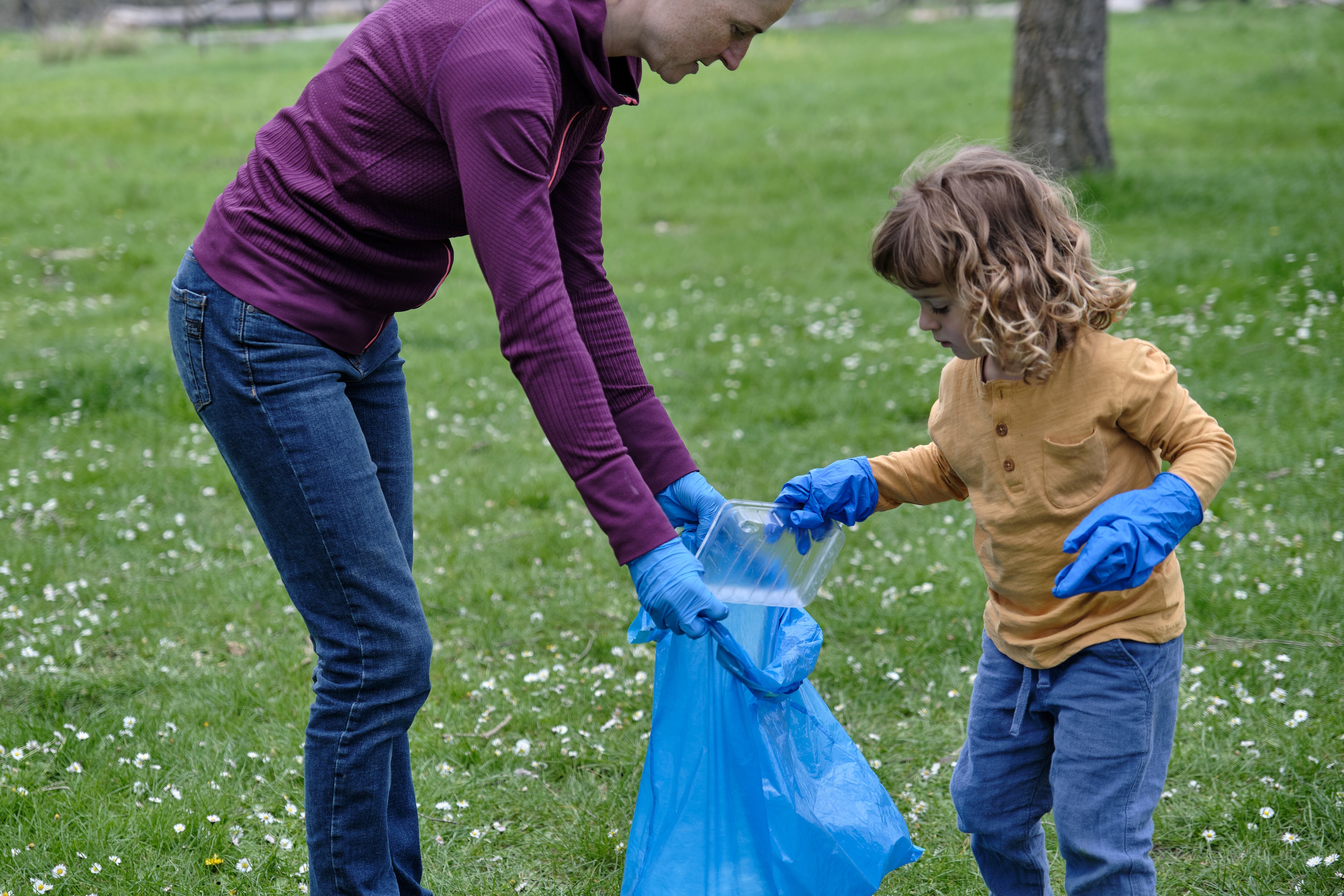 Little boy cleaning up nature with his mother