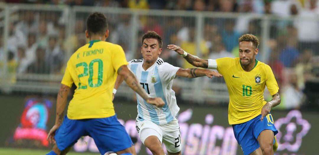 Neymar y Dybala pugnan por llevarse la pelota