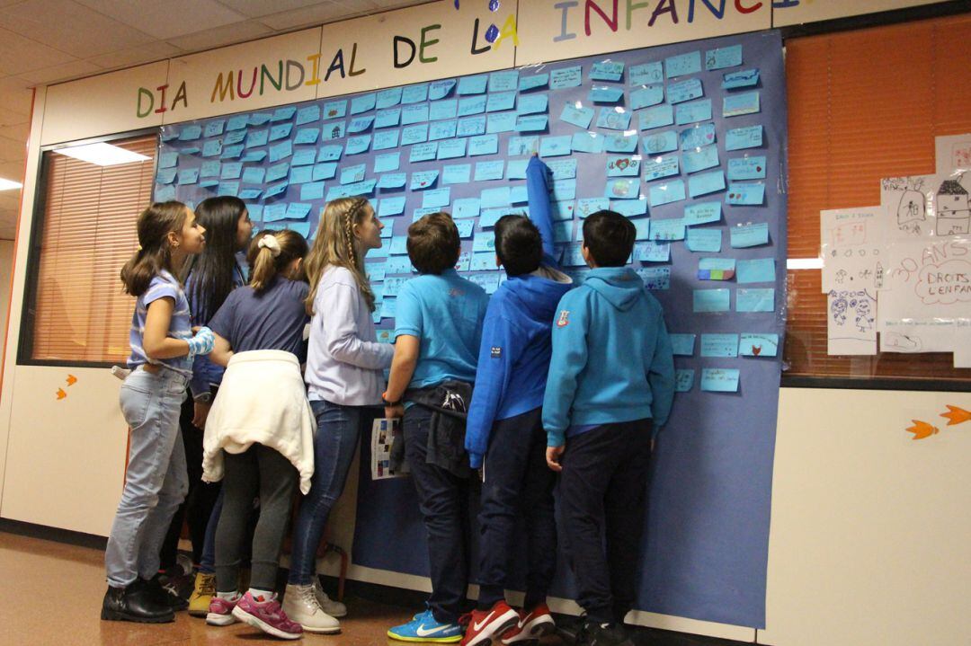 Els escolars d'Encamp davant el mural on han enganxat les seves inquietuds i drets.