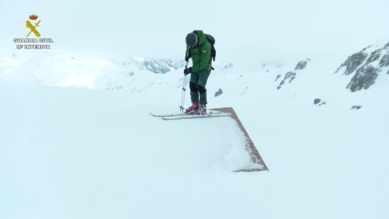 Un miembro del GREIM de Sabero camina sobre el refugio de Peñanevares totalmente cubierto por la nieve