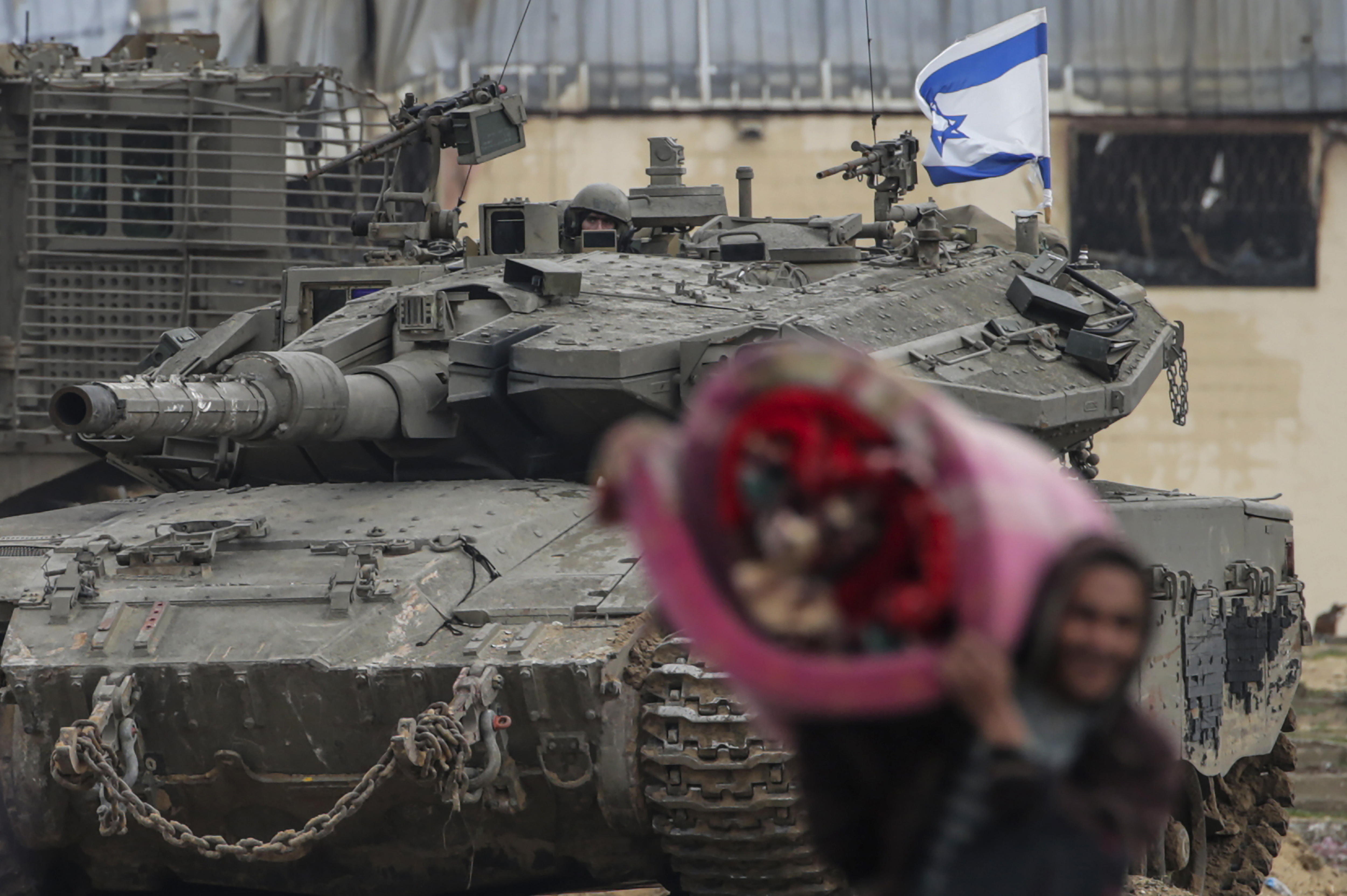 Imagen de un tanque israelí y un ciudadano palestino en la Franja de Gaza