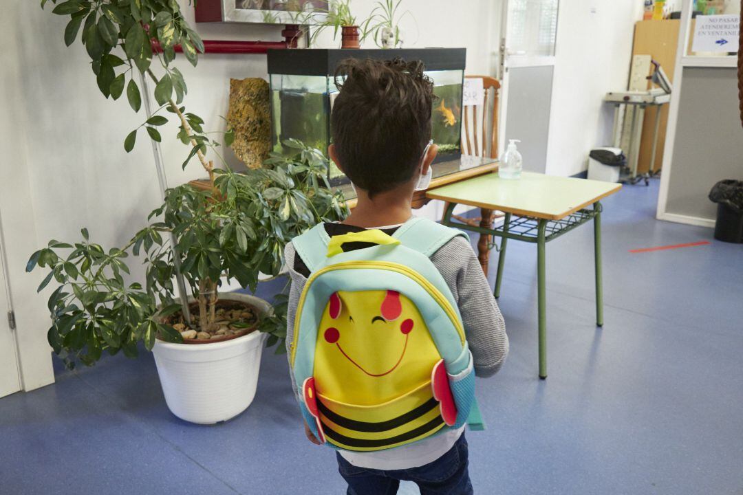 Un niño entra en un colegio.