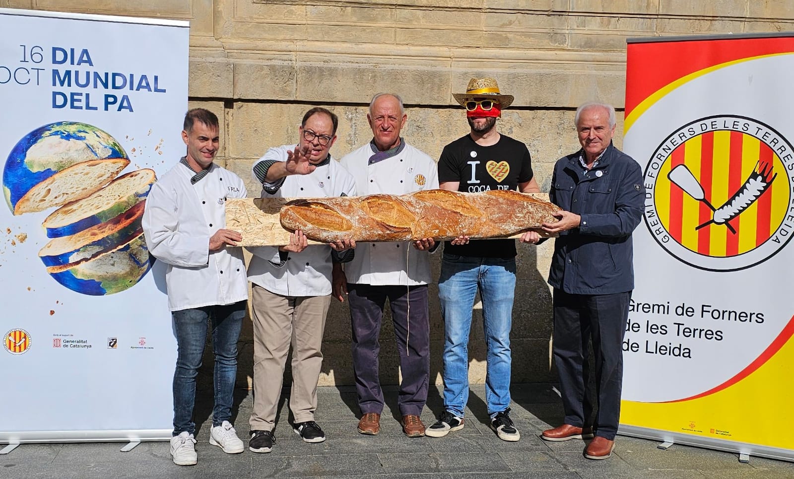 Amb motiu del Dia Mundial del Pa, el Gremi de Forners ha fet una acció reivindicativa i solidària amb el Sr. Postu davant de la Catedral. foto: Gremi de Forners