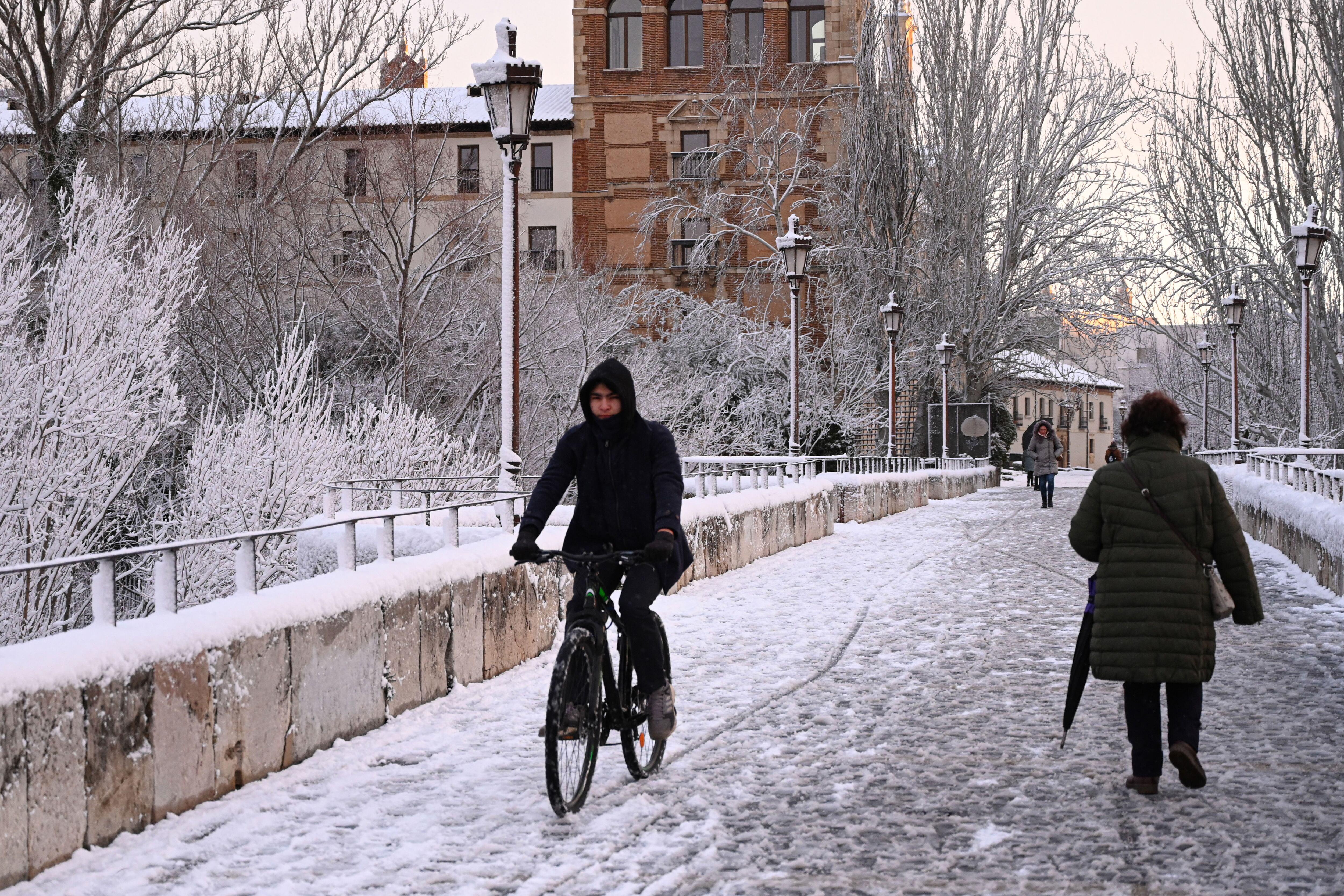 Varias personas cruzan una calle cubierta de nieve este miércoles en la capital leonesa