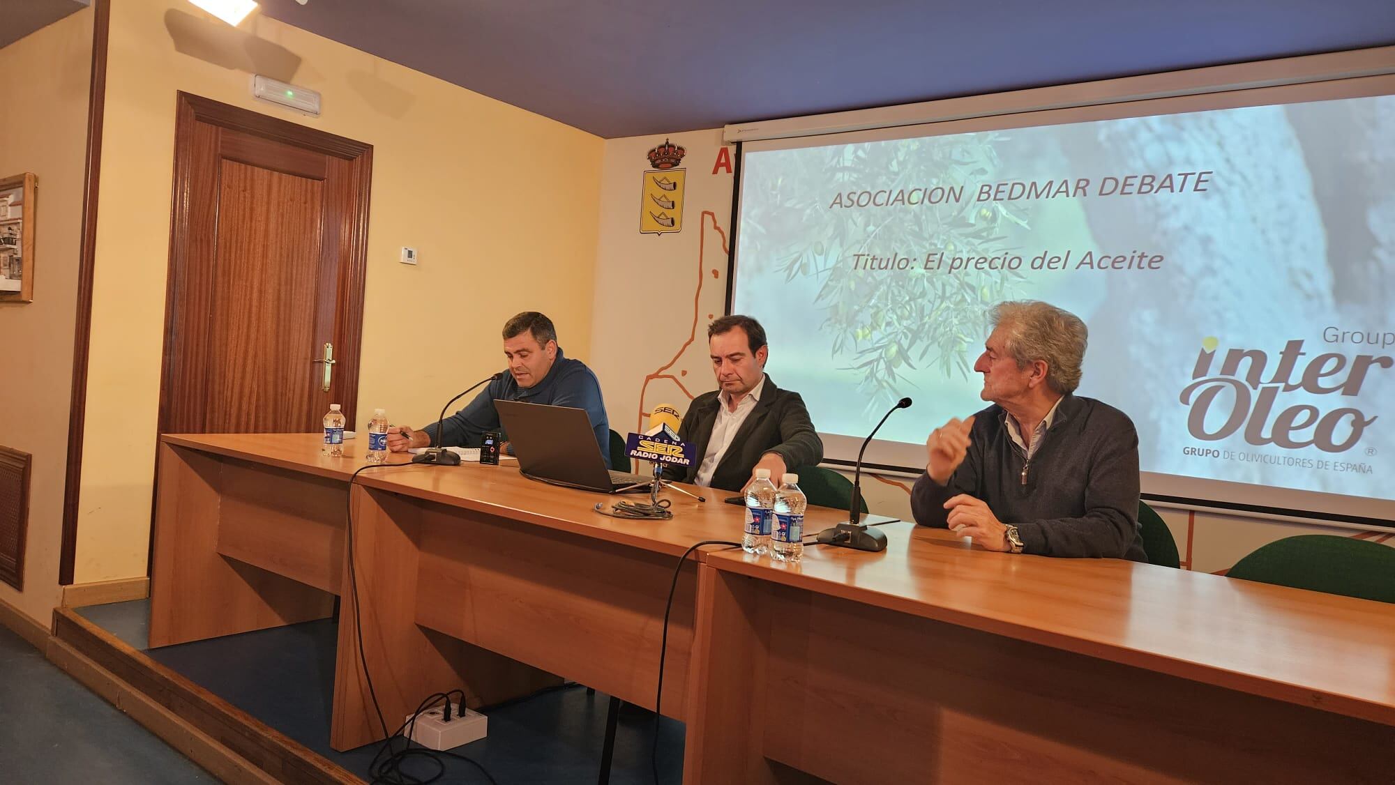 Momento de la presentación de la charla, de derecha a izquierda, Fernando Viedma, presidente de Bedmar Debate, el conferenciante Esteban Momblan, y Agapito Vega, presidente de la Cooperativa Bedmarense