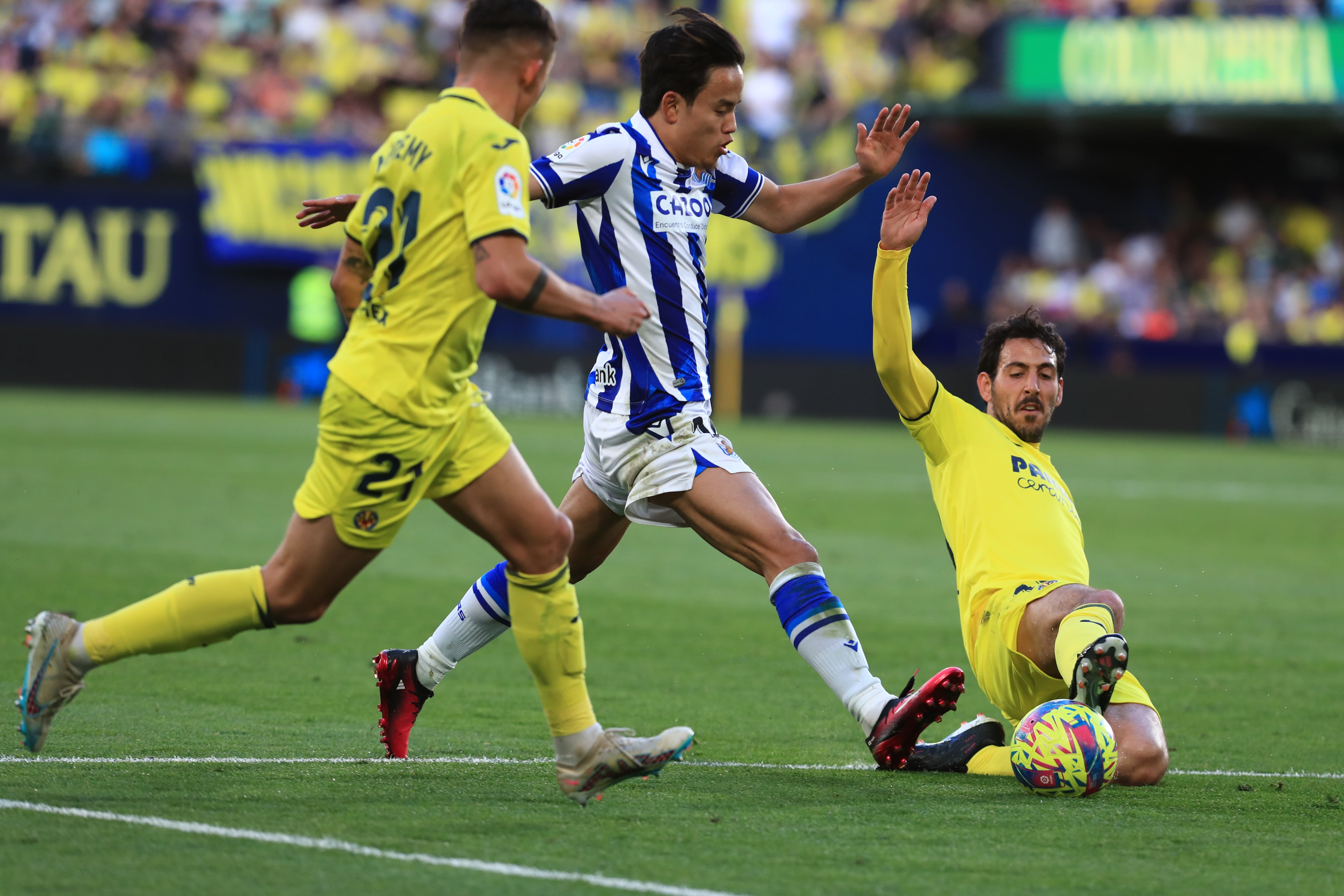 VILLARREAL, 02/04/2023.- El centrocampista japonés de la Real Sociedad, Takefusa Kubo (c), intenta llevarse el balón ante el centrocampista del Villarreal, Dani Parejo, durante el encuentro correspondiente a la jornada 27 de primera división que disputan hoy domingo en el estadio de La Cerámica, en la localidad castellonense. EFE / Domenech Castelló.
