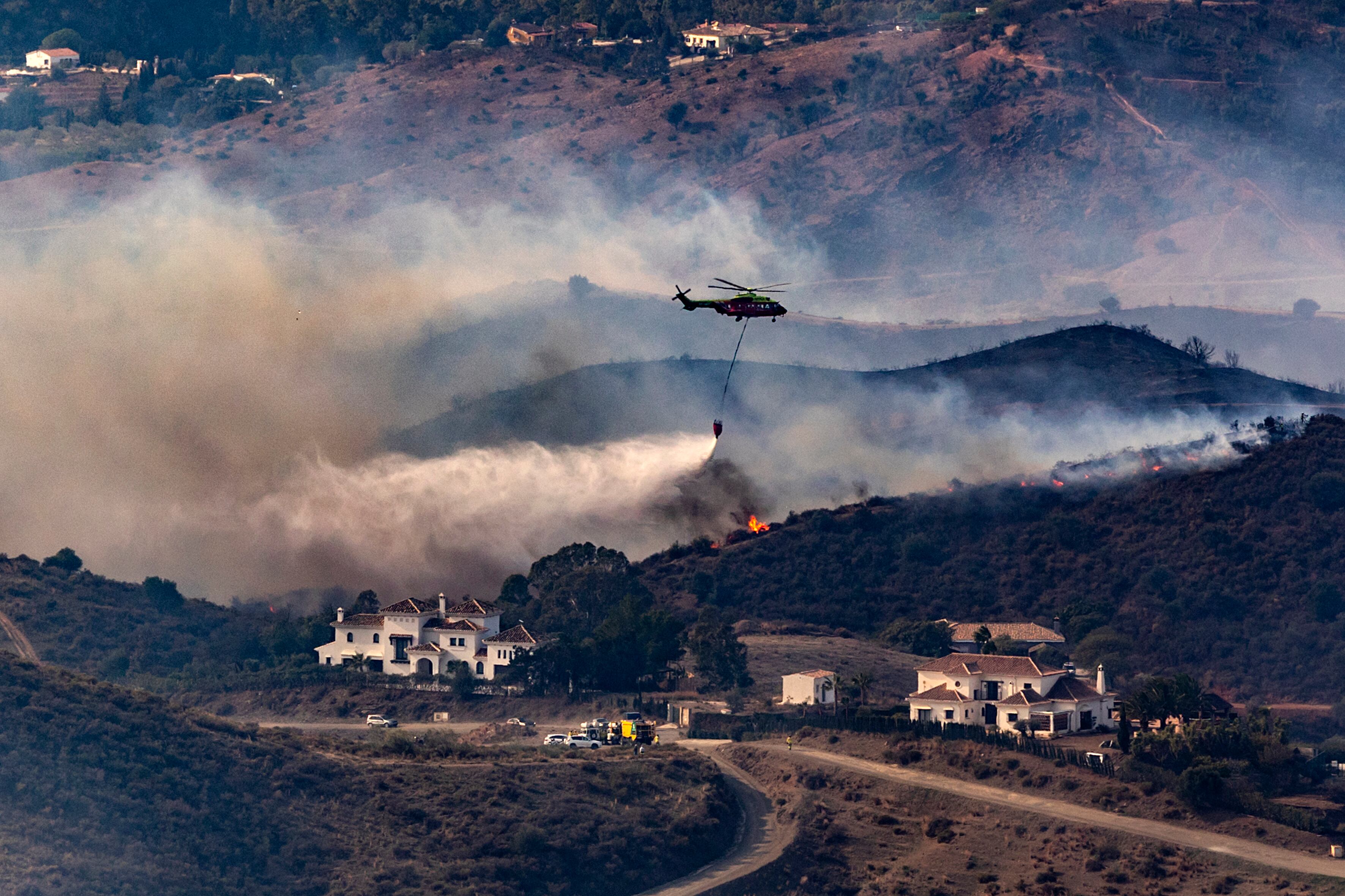 Mijas (Málaga), 12/11/2023.- Medios terrestres y aéreos trabajan en la extinción de un incendio forestal que se ha declarado esta madrugada en un paraje de Mijas (Málaga) conocido como Valtocado y que ha obligado a cortar la carretera A-387 entre los kilómetros 0 y 9,5 en ambos sentidos y a desalojar esta urbanización. EFE/Daniel Pérez
