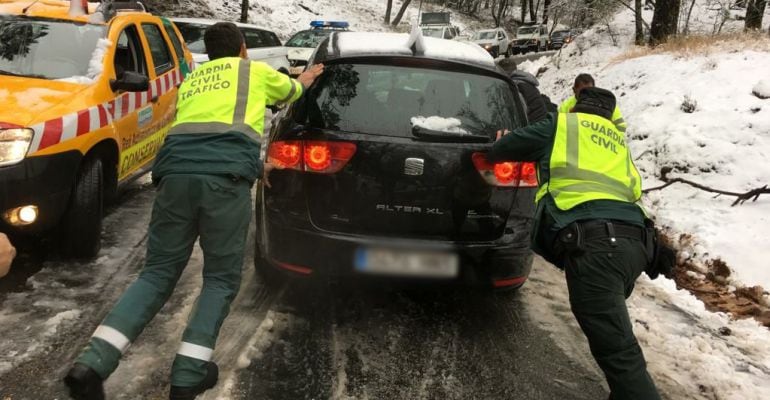 Varios guardias civiles ayudan a un coche atrapado en Cazorla.