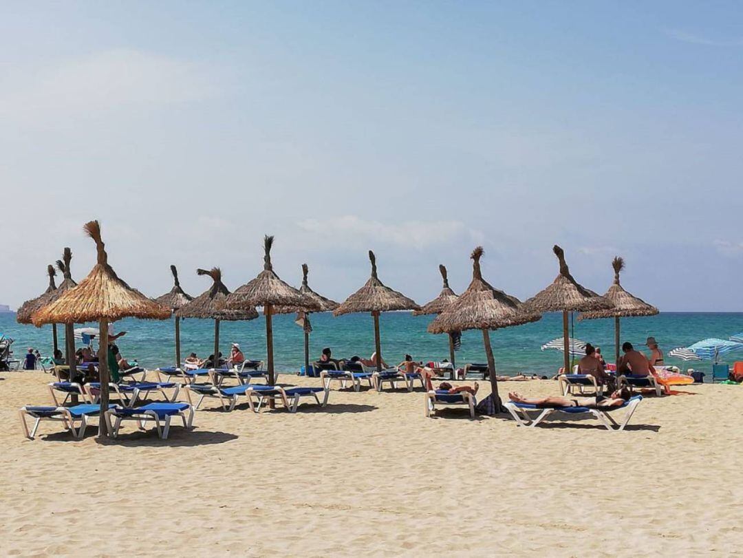 Turistas bajo la sombrilla en Playa de Palma 