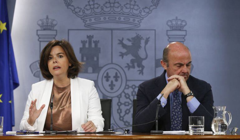 La vicepresidenta del Gobierno en funciones, Soraya Sáenz de Santamaría, y el ministro de Economía en funciones, Luis de Guindos.