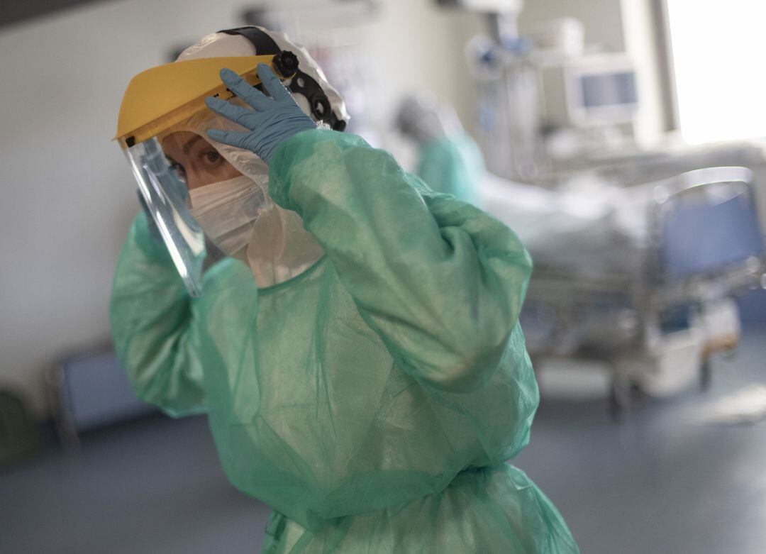Una sanitaria se retira la pantalla protectora en la Unidad de Cuidados Intensivos (UCI)