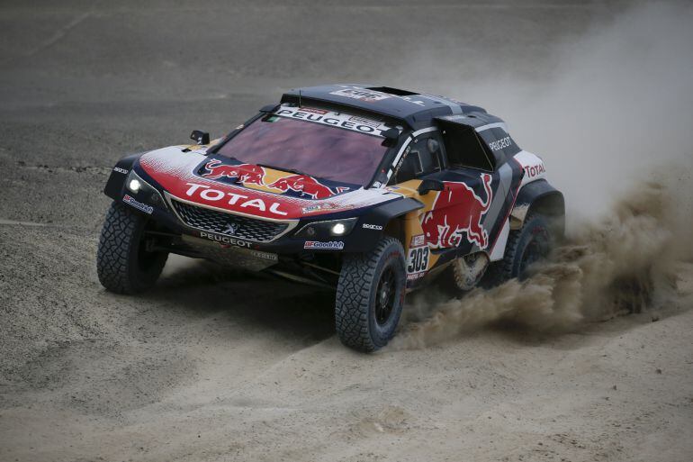 El equipo conformado por los españoles Carlos Sainz y su copiloto, Lucas Cruz, de Peugeot, participa durante la segunda etapa del Dakar 2018.