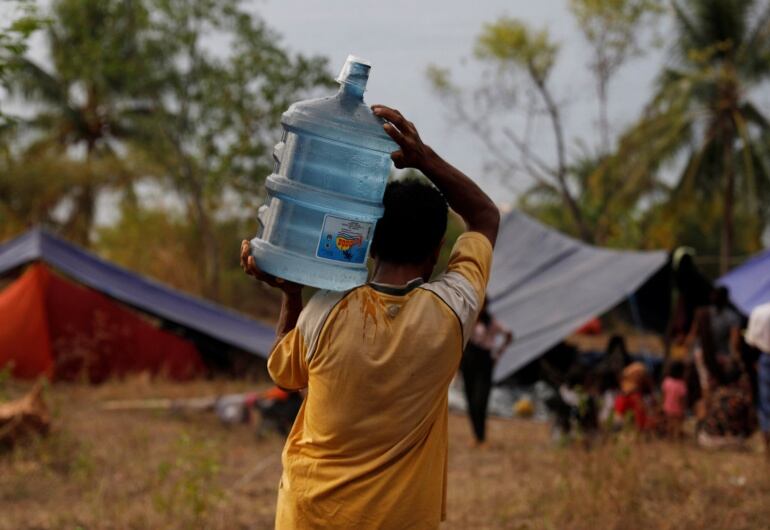 Un habitante de la isla indonesia de Lombok carga una garrafa de agua en uno de los campamentos instalados tras los terremotos