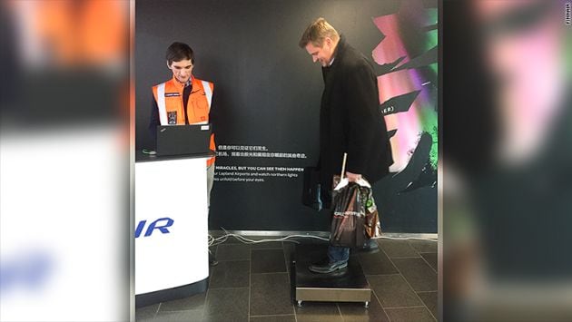 Un pasajero se pesa en el aeropuerto de Helsinki.